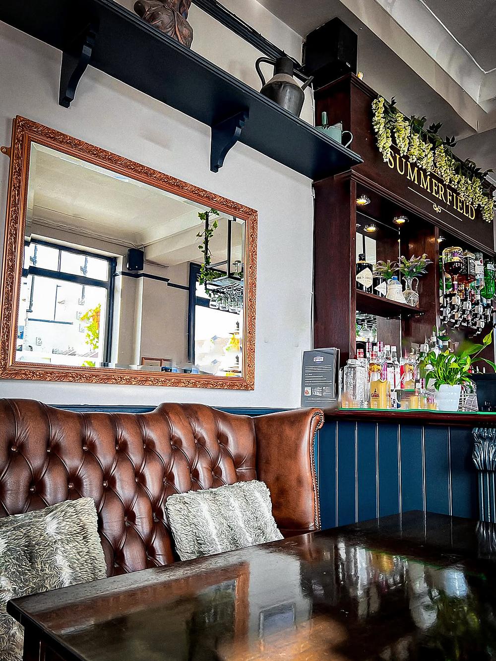 Leather booths by the window inside The Summerfield
