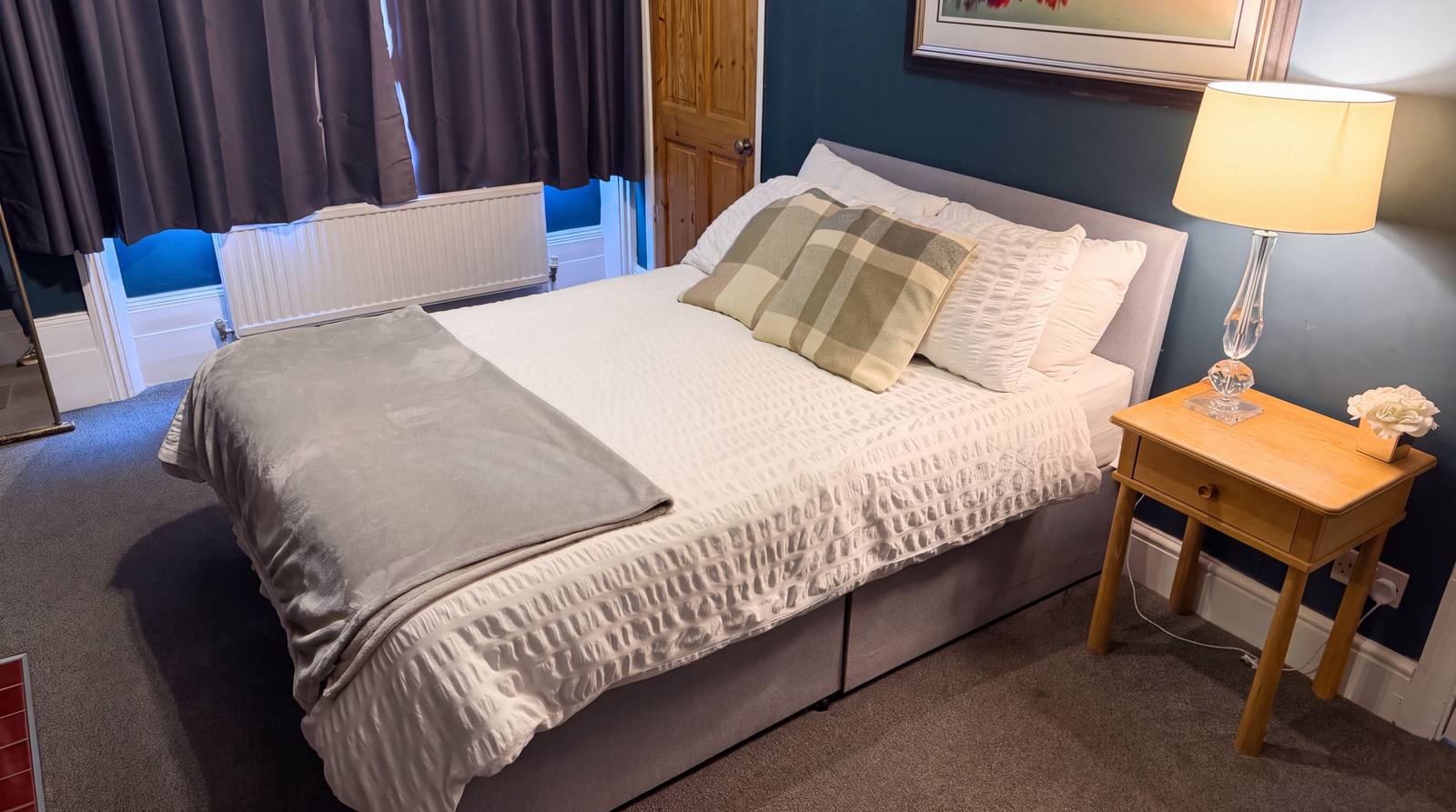 A bright guest room with tartan cushions